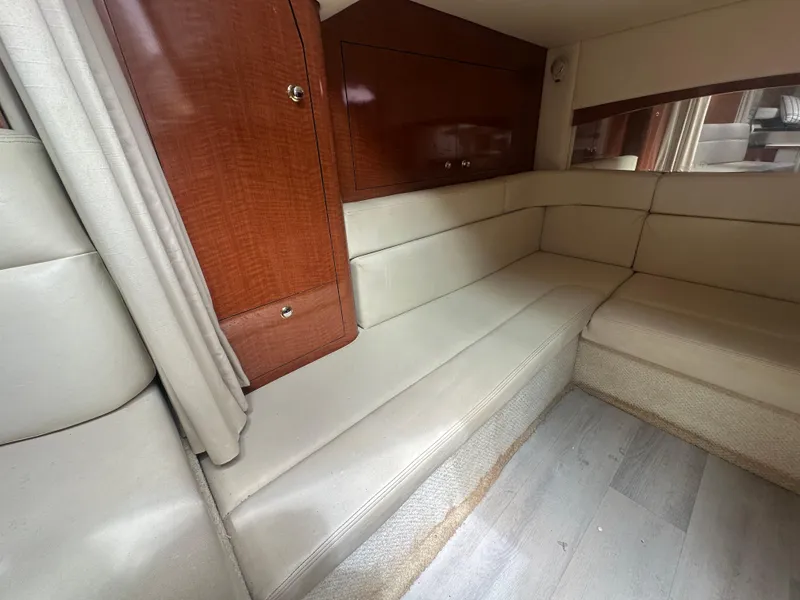 Slide: The Image of 2004 Sea Ray 340 Sundancer interior with beige seating and wooden cabinetry. - 31