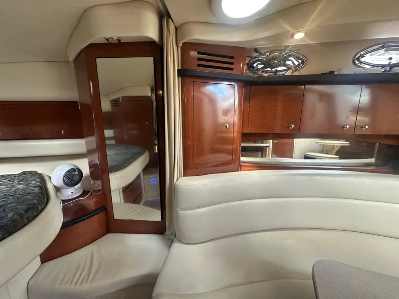 Slide: The Image of Interior of 2004 Sea Ray 340 Sundancer with wood cabinets and cream seating. - 33