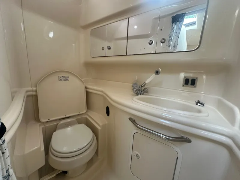 Slide: The Image of 2004 Sea Ray 340 Sundancer bathroom with toilet, sink, and storage cabinets. - 42