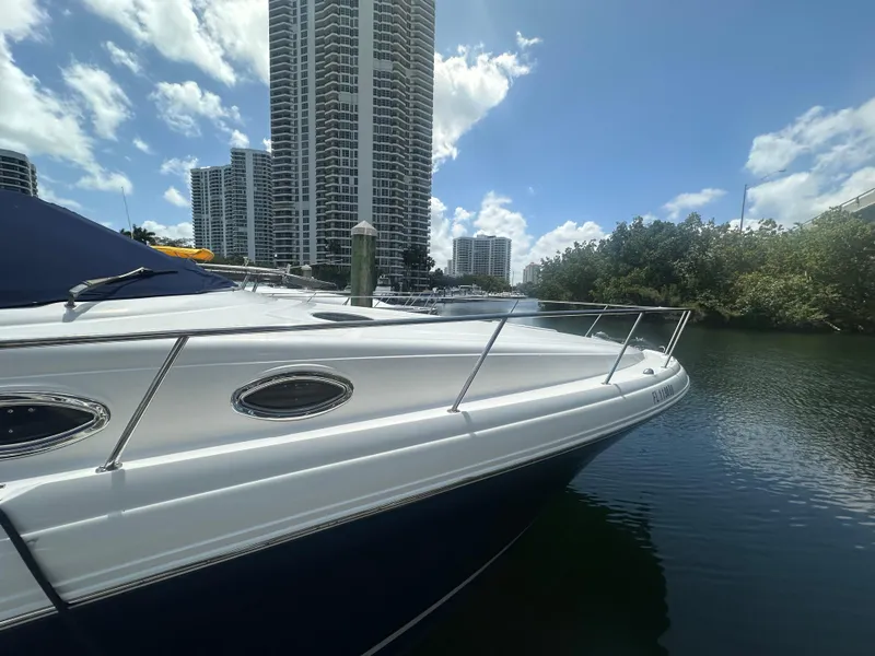Slide: The Image of 2004 Sea Ray 340 Sundancer yacht docked near high-rise buildings and trees. - 5