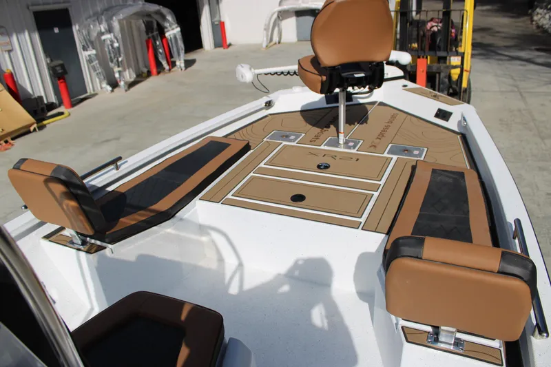 Slide: The Image of 2026 Xpress XR21B Bay boat interior with brown seating and storage compartments. - 8