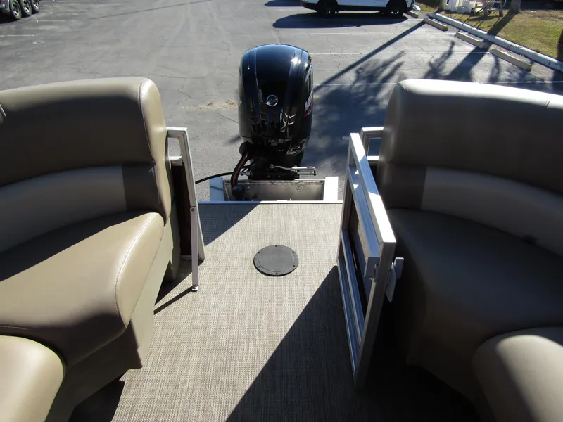 Slide: The Image of 2024 Starcraft LX 20 R pontoon boat interior with seating and outboard motor. - 22