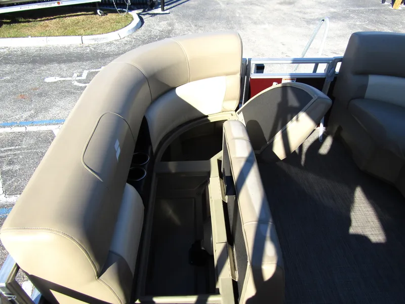 Slide: The Image of 2024 Starcraft LX 20 R pontoon boat interior with beige seating and storage compartments. - 9