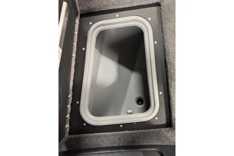 Slide: The Image of 2026 Tracker Targa V-19 WT storage compartment with gray interior and secure lid. - 20