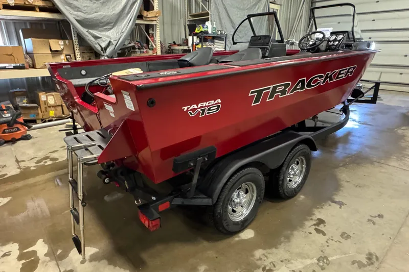 Slide: The Image of 2026 Tracker Targa V-19 WT boat in a garage, red exterior, on a trailer. - 4