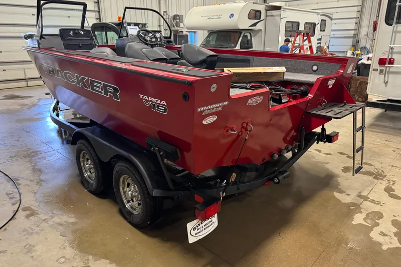 Slide: The Image of 2026 Tracker Targa V-19 WT boat in a garage, red exterior, on a trailer. - 5
