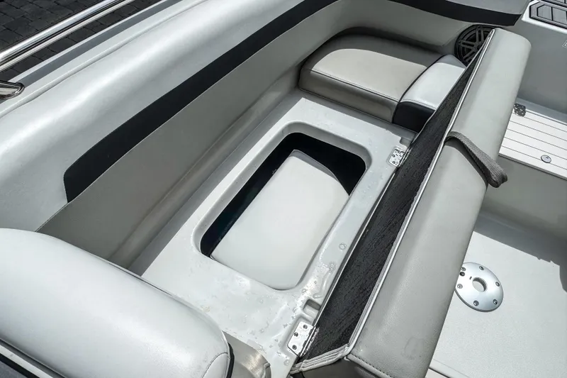 Slide: The Image of 2024 Starcraft SVX 211 OB boat interior with open storage compartment and cushioned seating. - 15