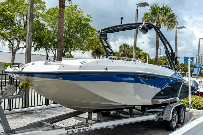 Slide: The Image of 2024 Starcraft SVX 211 OB boat on trailer, blue and white design, outdoor display. - 3