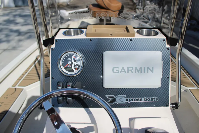 Slide: The Image of 2026 Xpress H20B Bay boat dashboard with Garmin display and controls. - 16