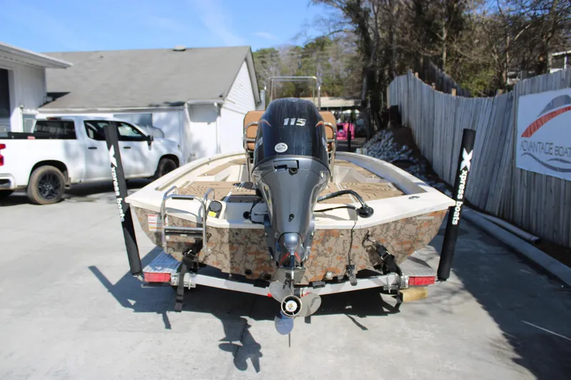 Slide: The Image of 2026 Xpress H20B Bay boat on trailer with outboard motor, parked outdoors. - 3