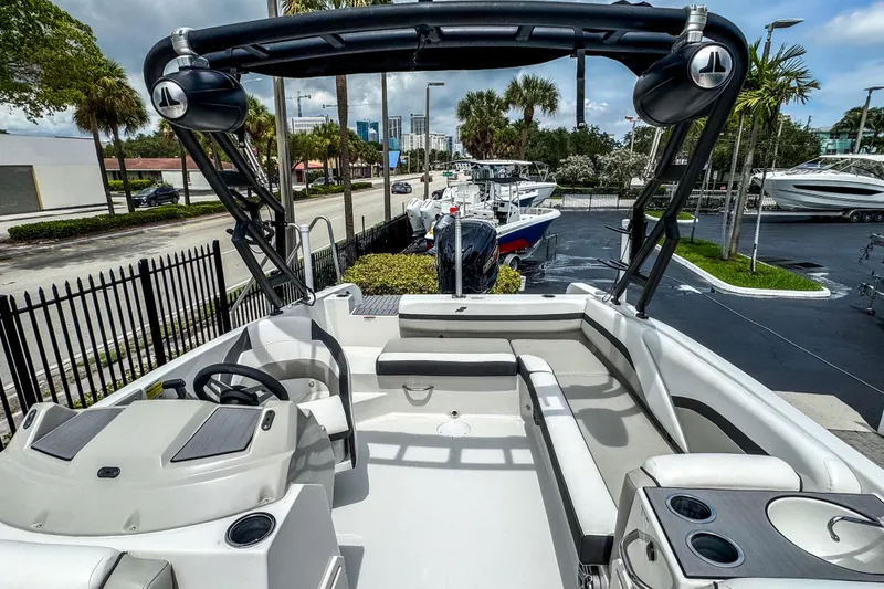 Slide: The Image of 2024 Starcraft SVX 211 OB boat interior with seating and steering wheel, parked outdoors. - 6