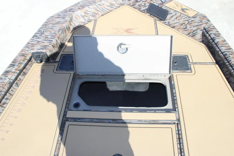 Slide: The Image of 2026 Xpress X18DB boat interior with open storage compartment and camouflage design. - 10