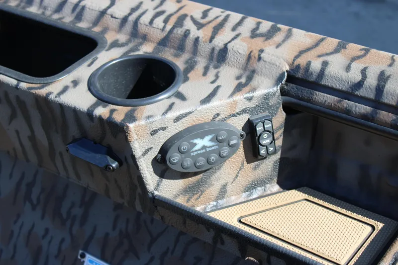 Slide: The Image of 2026 Xpress X18DB boat console with camouflage design and control panel. - 13