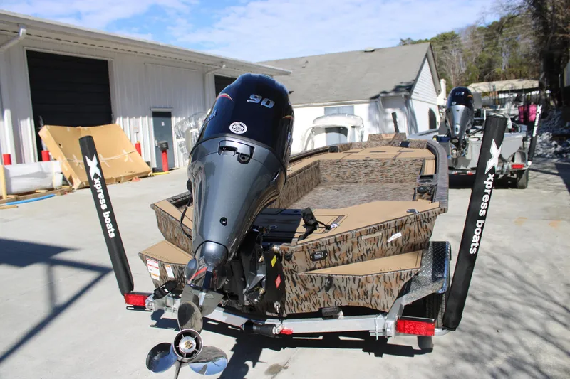 Slide: The Image of 2026 Xpress X18DB boat with camo design and powerful outboard motor on trailer. - 7
