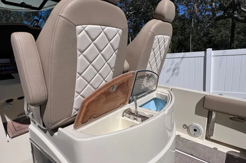 Slide: The Image of 2022 Chris-Craft Catalina 30 interior with beige quilted seats and storage compartment. - 18