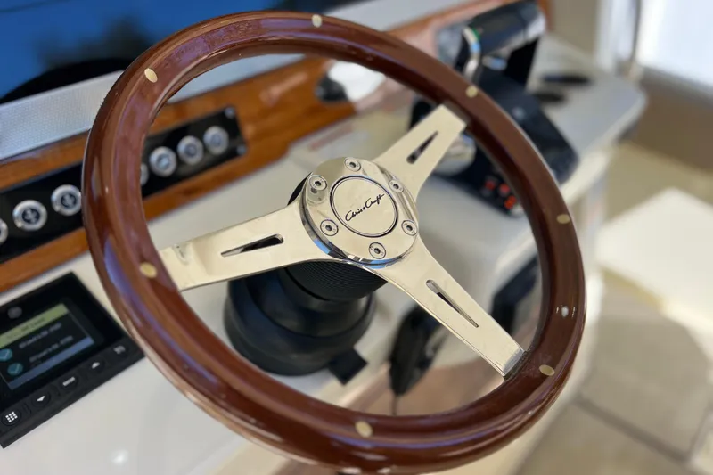 Slide: The Image of Steering wheel of 2022 Chris-Craft Catalina 30 boat, featuring elegant wood and metal design. - 34