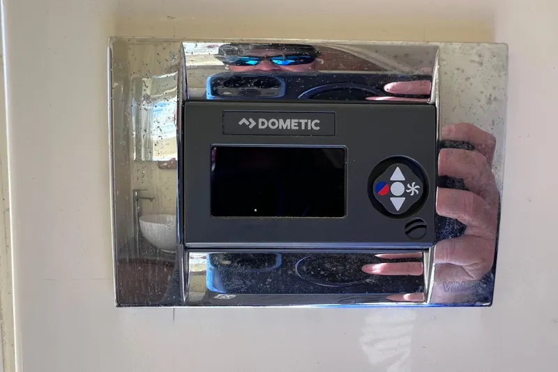 Slide: The Image of Dometic control panel on 2022 Chris-Craft Catalina 30 boat, reflecting surroundings. - 54