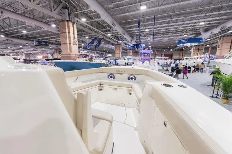 Slide: The Image of 2026 Solace 30 CS boat interior at an indoor boat show, showcasing luxury seating. - 2
