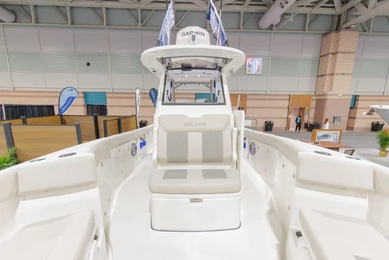 Slide: The Image of 2026 Solace 30 CS boat interior at an indoor exhibition, showcasing seating and helm. - 3