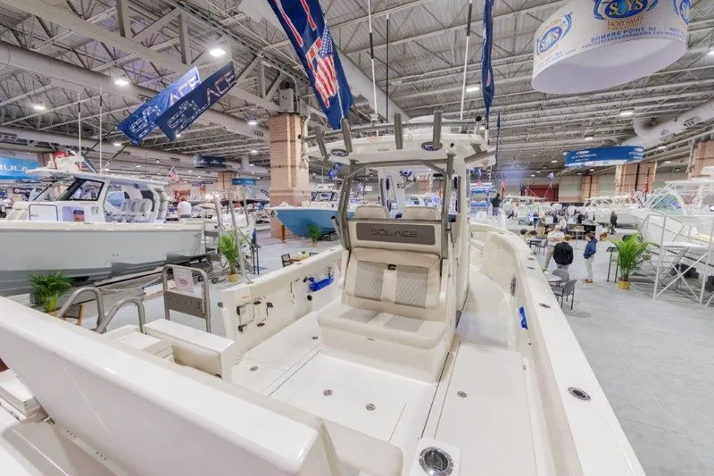Slide: The Image of 2026 Solace 30 CS boat displayed at an indoor boat show, showcasing sleek design and features. - 7