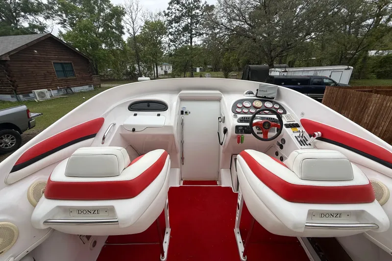 Slide: The Image of 1998 Donzi 33 ZX boat cockpit with red and white seating, steering wheel, and control panel. - 11