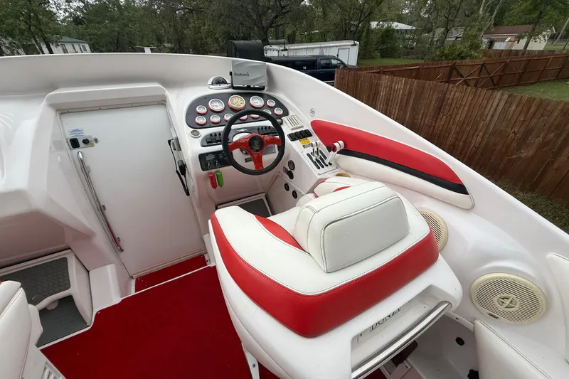 Slide: The Image of 1998 Donzi 33 ZX boat cockpit with red and white seating, steering wheel, and control panel. - 13