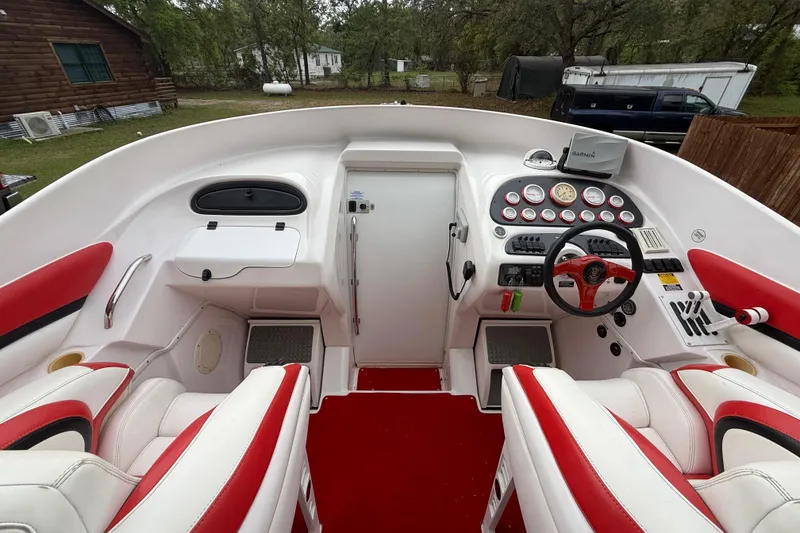 Slide: The Image of 1998 Donzi 33 ZX boat cockpit with red and white seating, steering wheel, and control panel. - 23