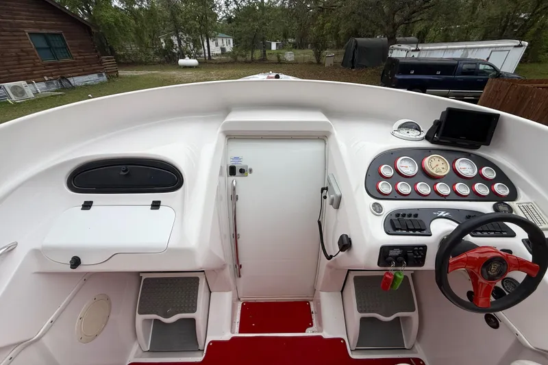 Slide: The Image of 1998 Donzi 33 ZX boat cockpit with steering wheel, gauges, and control panel. - 26