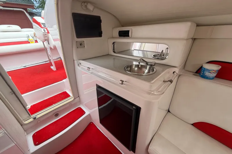 Slide: The Image of Interior of 1998 Donzi 33 ZX boat featuring kitchenette with sink and red carpet. - 40