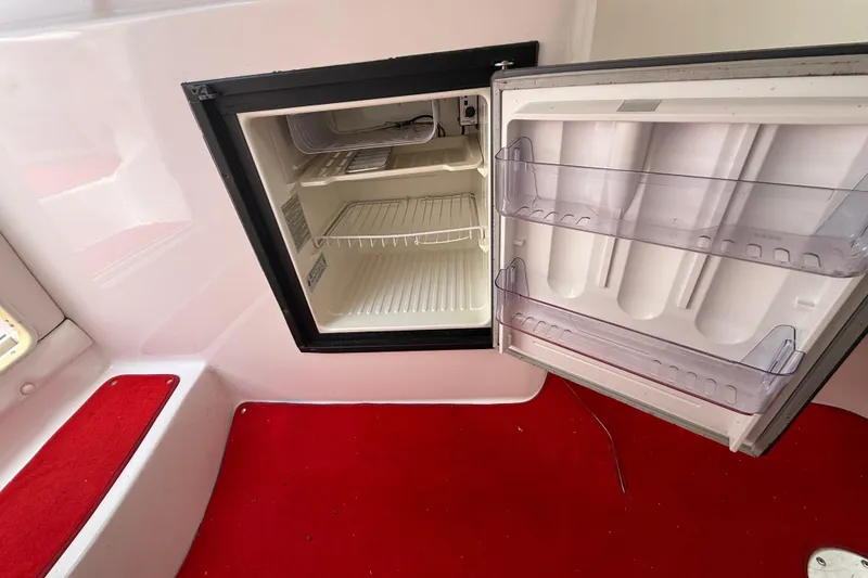 Slide: The Image of Open mini fridge inside 1998 Donzi 33 ZX boat with red carpet flooring. - 43