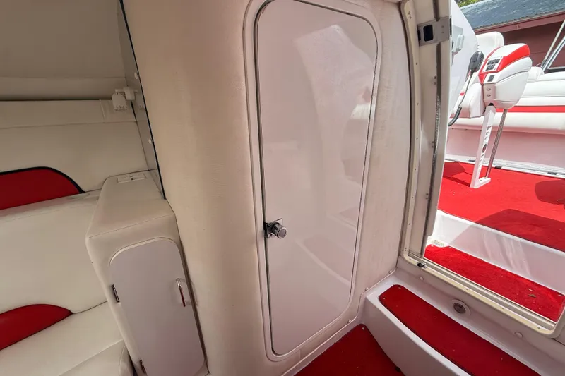 Slide: The Image of Interior of a 1998 Donzi 33 ZX boat, featuring white and red seating. - 48