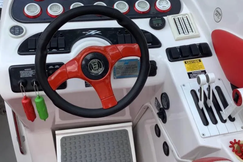 Slide: The Image of 1998 Donzi 33 ZX boat dashboard with red steering wheel and control panel. - 5