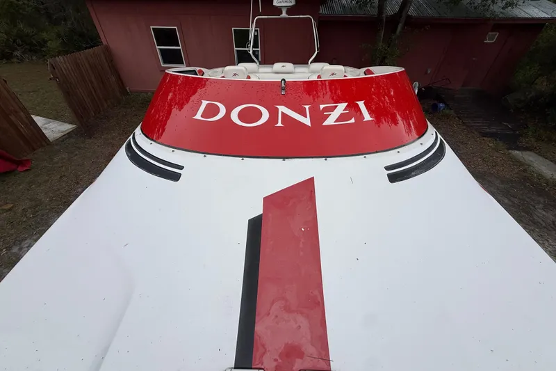 Slide: The Image of 1998 Donzi 33 ZX boat with red and white design, parked outdoors. - 57