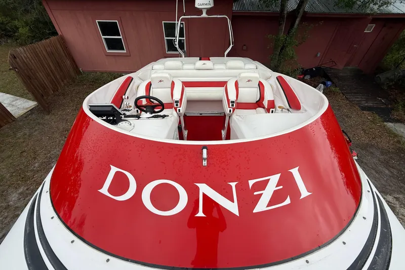 Slide: The Image of 1998 Donzi 33 ZX speedboat with red and white interior, parked near a building. - 58