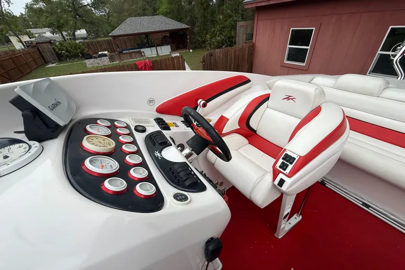 Slide: The Image of Cockpit of a 1998 Donzi 33 ZX boat with red and white seating and dashboard controls. - 59