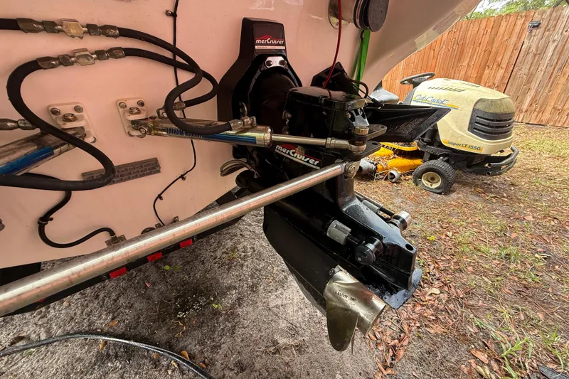 Slide: The Image of 1998 Donzi 33 ZX boat with MerCruiser engine, parked near a Cub Cadet lawn tractor. - 75