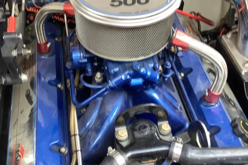 Slide: The Image of Engine of a 1998 Donzi 33 ZX boat, featuring a blue intake manifold. - 9