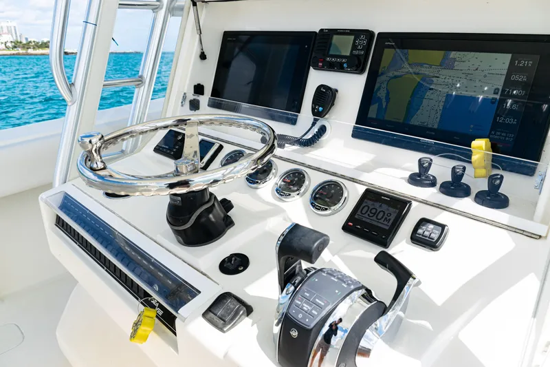 Slide: The Image of Control panel of a 2018 SeaVee 370Z boat with navigation screens and steering wheel. - 27