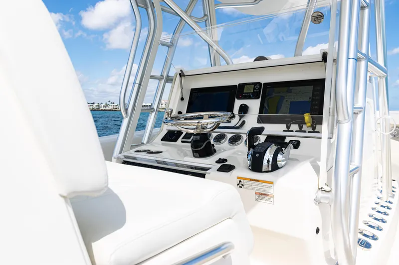 Slide: The Image of 2018 SeaVee 370Z boat helm with modern navigation equipment and controls, set against a clear blue sky. - 29
