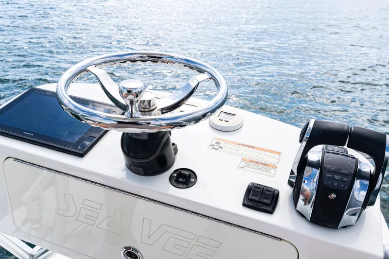 Slide: The Image of Control panel of a 2018 SeaVee 370Z boat with steering wheel and navigation equipment. - 48