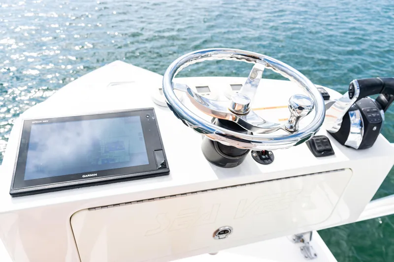 Slide: The Image of 2018 SeaVee 370Z helm with Garmin display and chrome steering wheel on open water. - 49