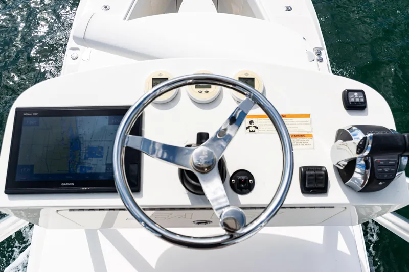 Slide: The Image of 2018 SeaVee 370Z boat helm with steering wheel, GPS display, and controls on open water. - 51