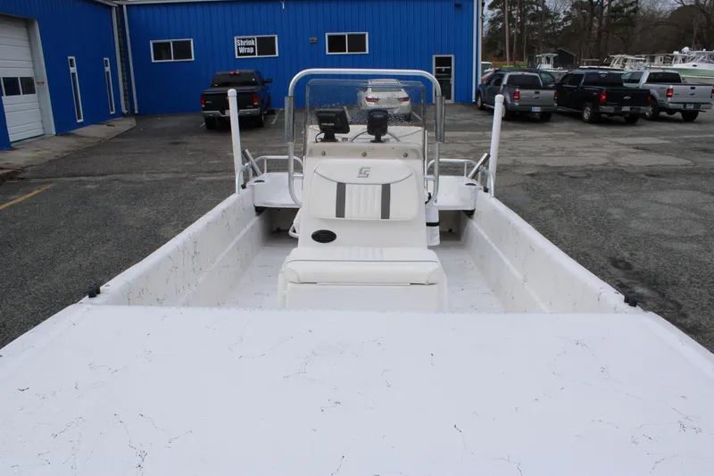 Slide: The Image of 2009 Carolina Skiff 17 DLX boat in a parking lot, blue building background. - 12