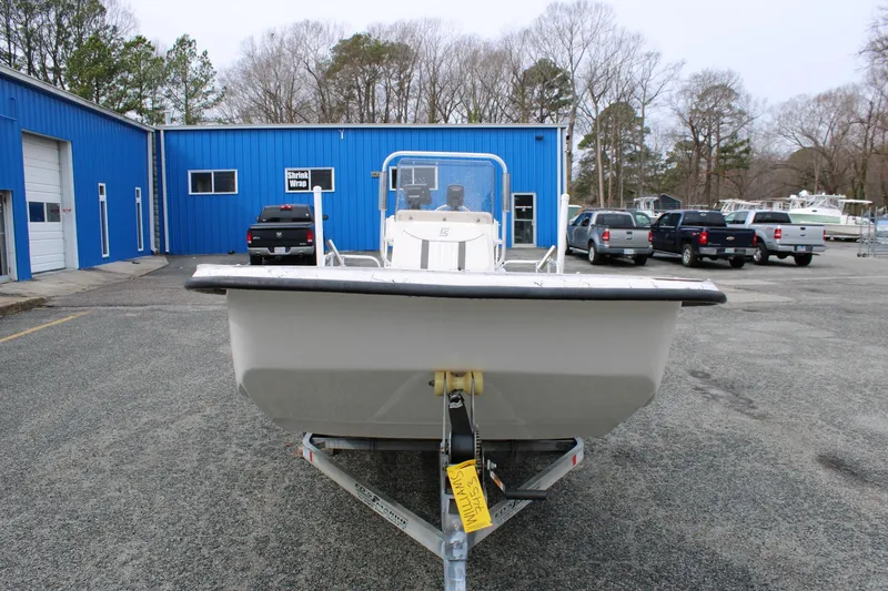 Slide: The Image of 2009 Carolina Skiff 17 DLX boat on trailer, parked outside blue building. - 2