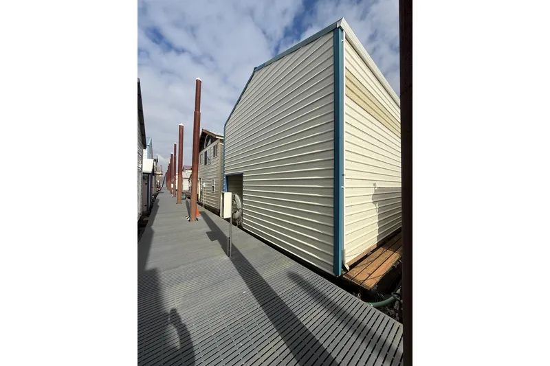 The Image of 1940 custom boathouse with wooden siding and dock, under a partly cloudy sky. - 1