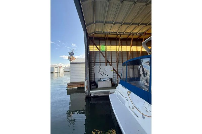 Slide: The Image of 1940 custom boathouse with docked boat, clear sky, and calm water. - 10