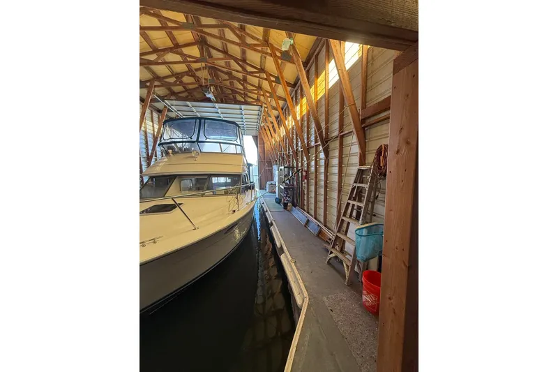 Slide: The Image of 1940 custom boathouse interior with docked boat, wooden beams, and storage items. - 16