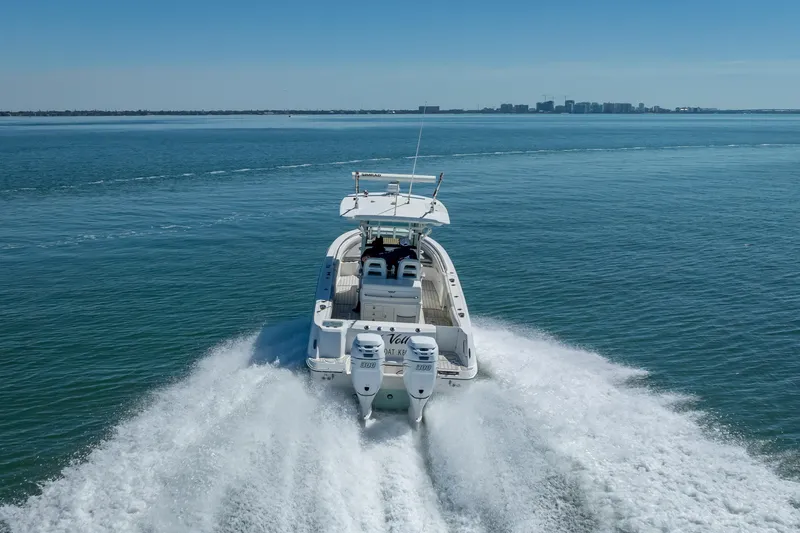 Slide: The Image of 2013 Boston Whaler 320 Outrage cruising on open water, rear view. - 14