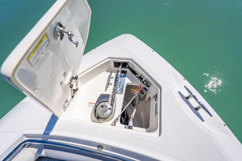 Slide: The Image of Open anchor compartment on 2013 Boston Whaler 320 Outrage, showing anchor and chain mechanism. - 18