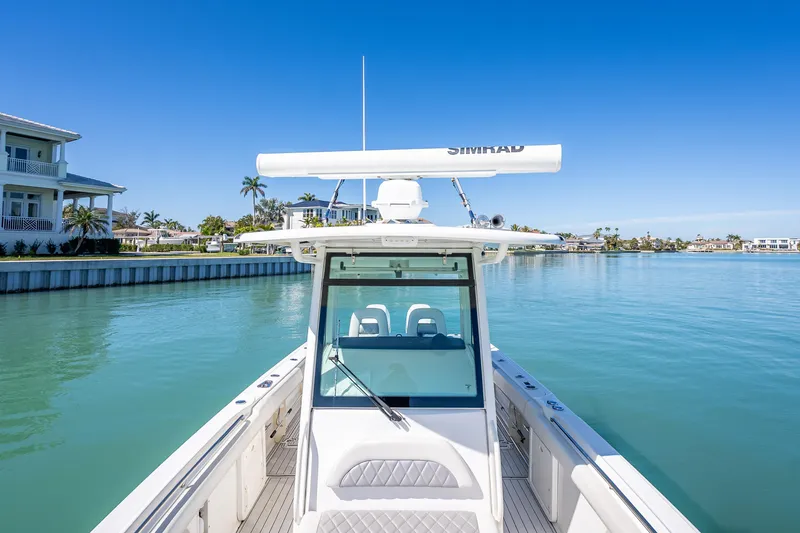 Slide: The Image of 2013 Boston Whaler 320 Outrage on calm water, clear sky, luxury waterfront homes. - 21